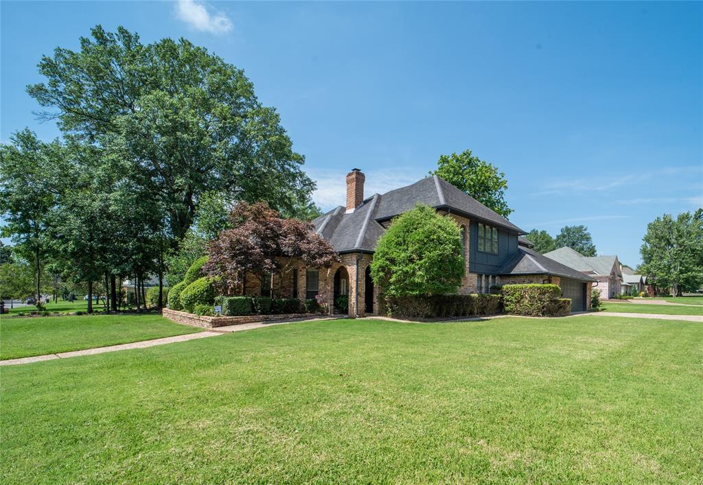 a front view of a house with a yard and trees