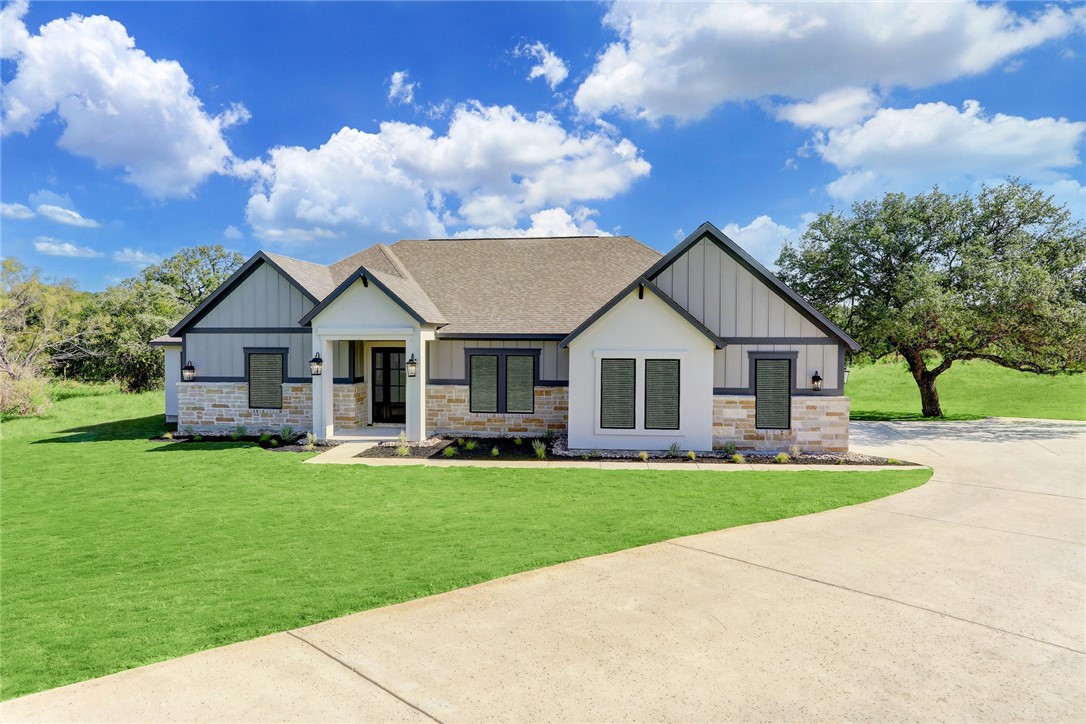 a front view of a house with a yard and trees