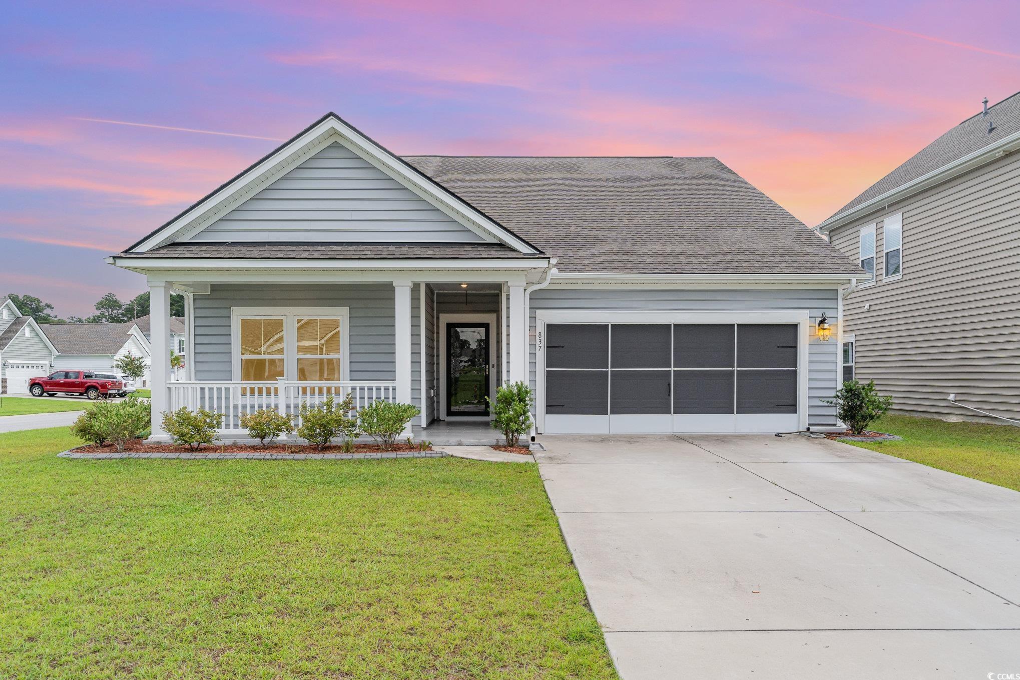 View of front of home featuring a porch, a garage,