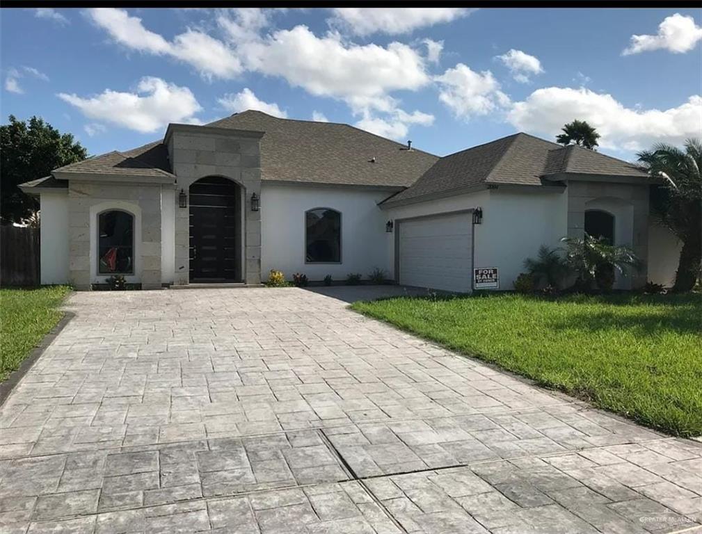 a view of house with yard and a garage