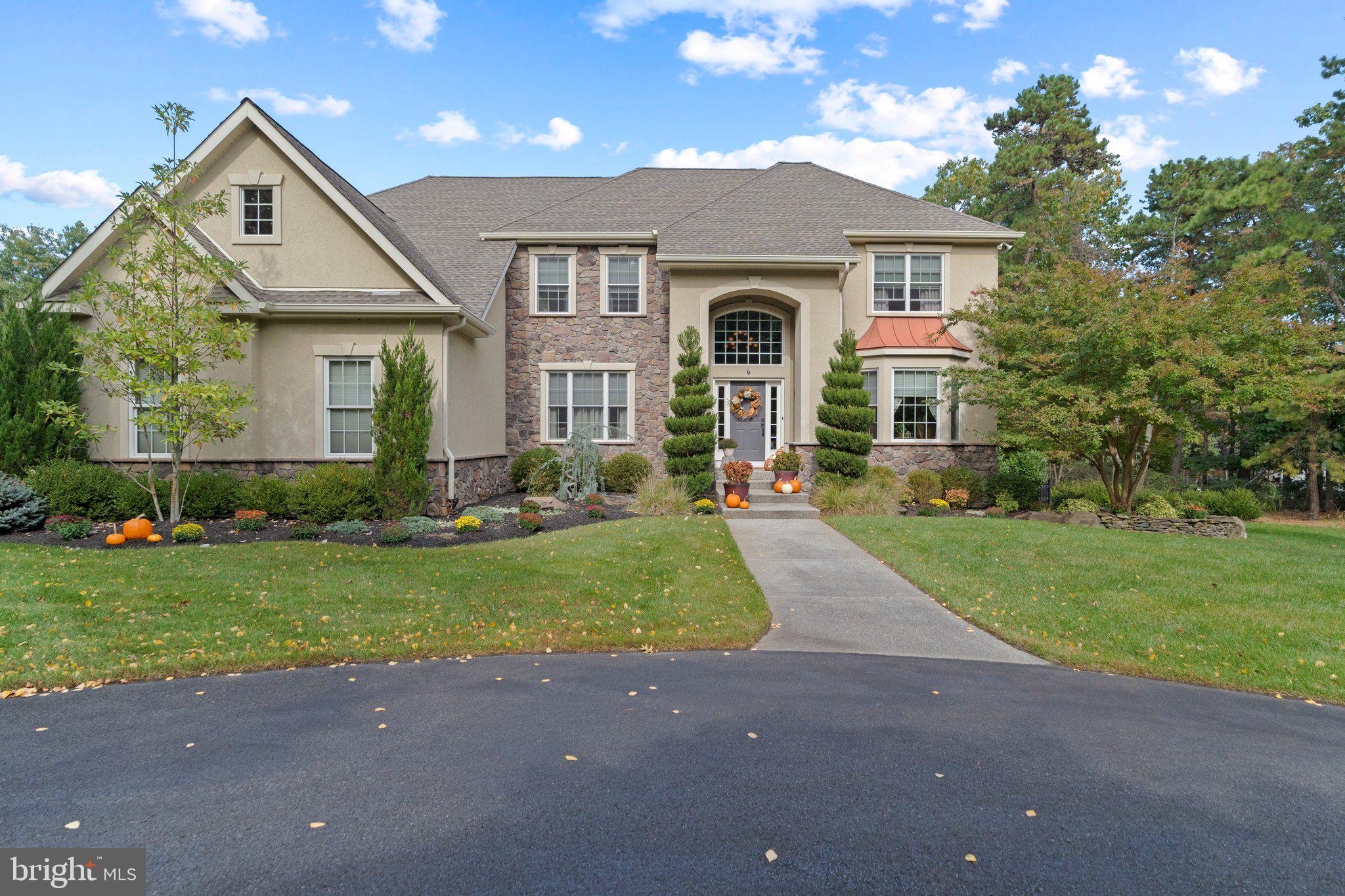 a front view of a house with a yard and trees