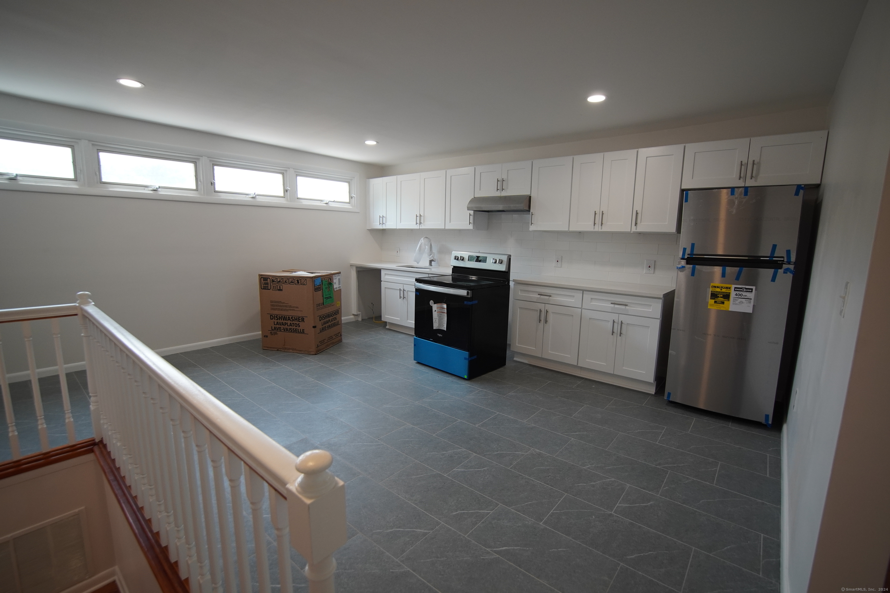 a kitchen with stainless steel appliances a refrigerator sink and white cabinets