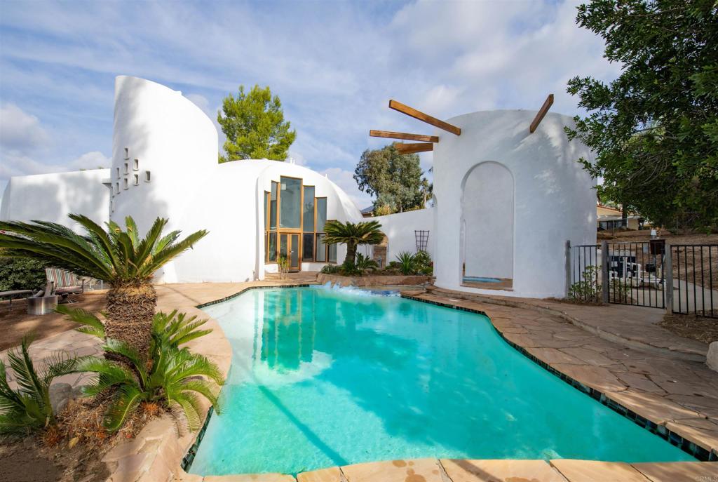 a view of an house with backyard and sitting area