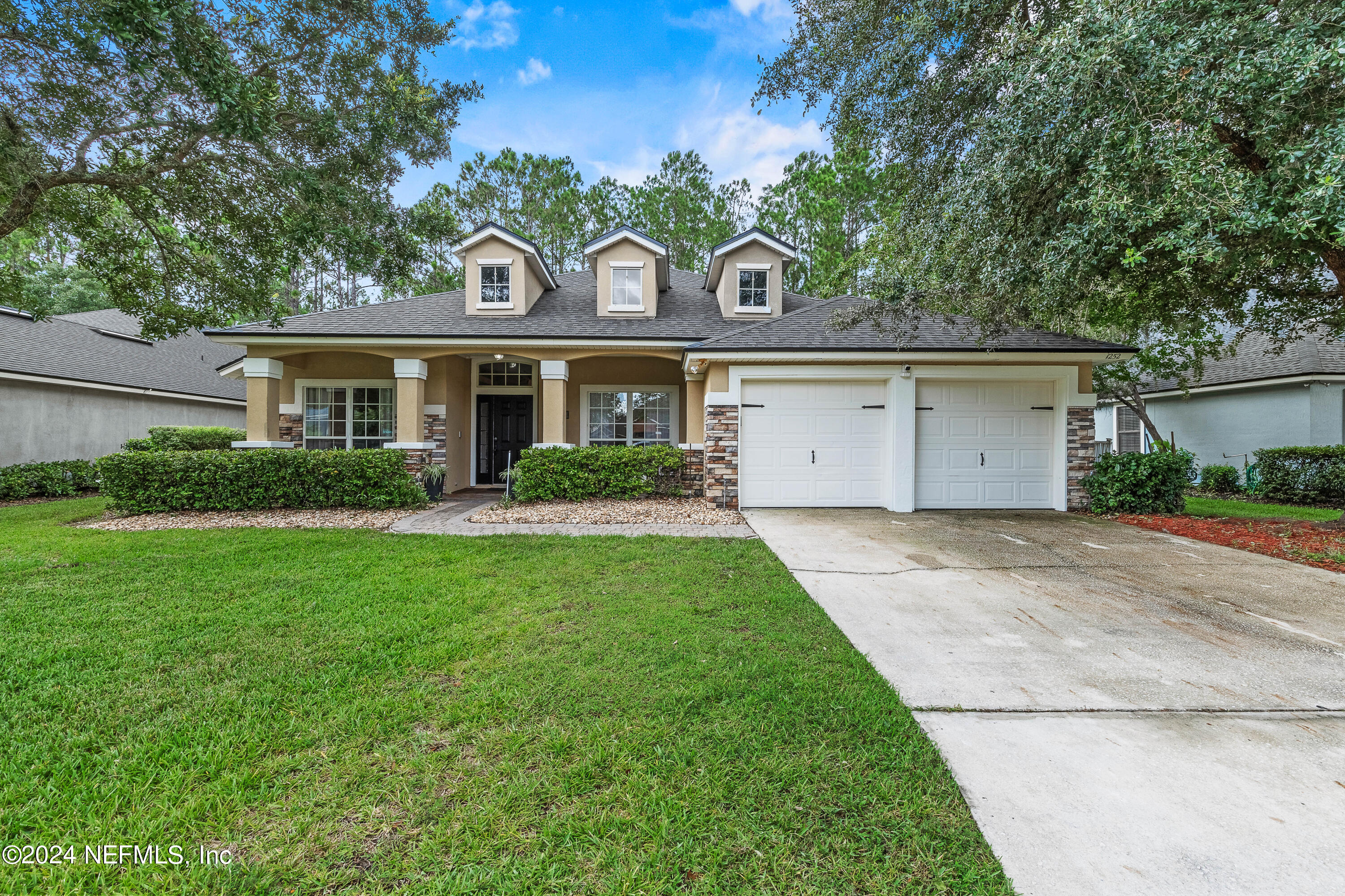 a front view of house with yard and green space