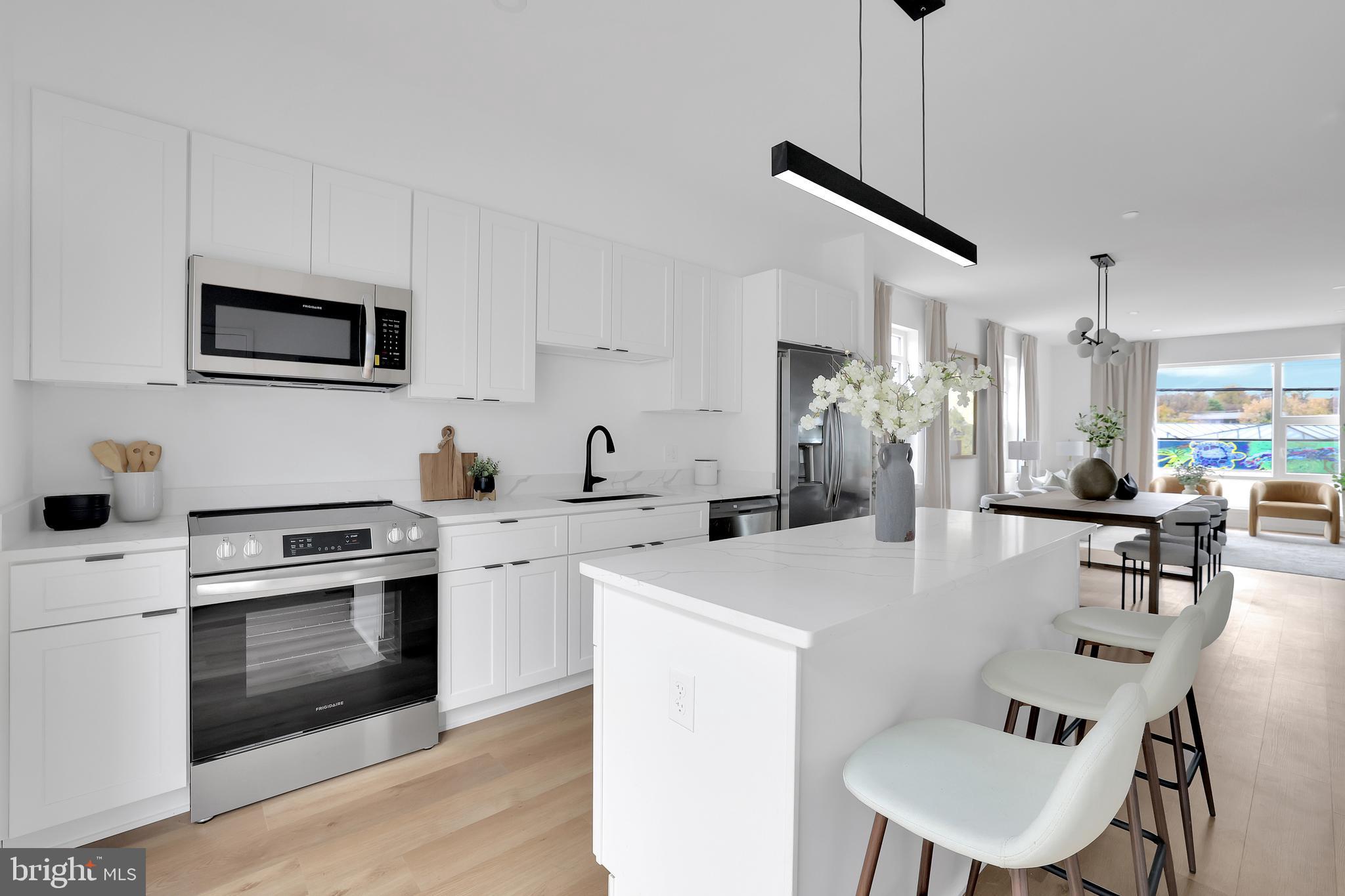 a kitchen with stainless steel appliances kitchen island a table and chairs in it