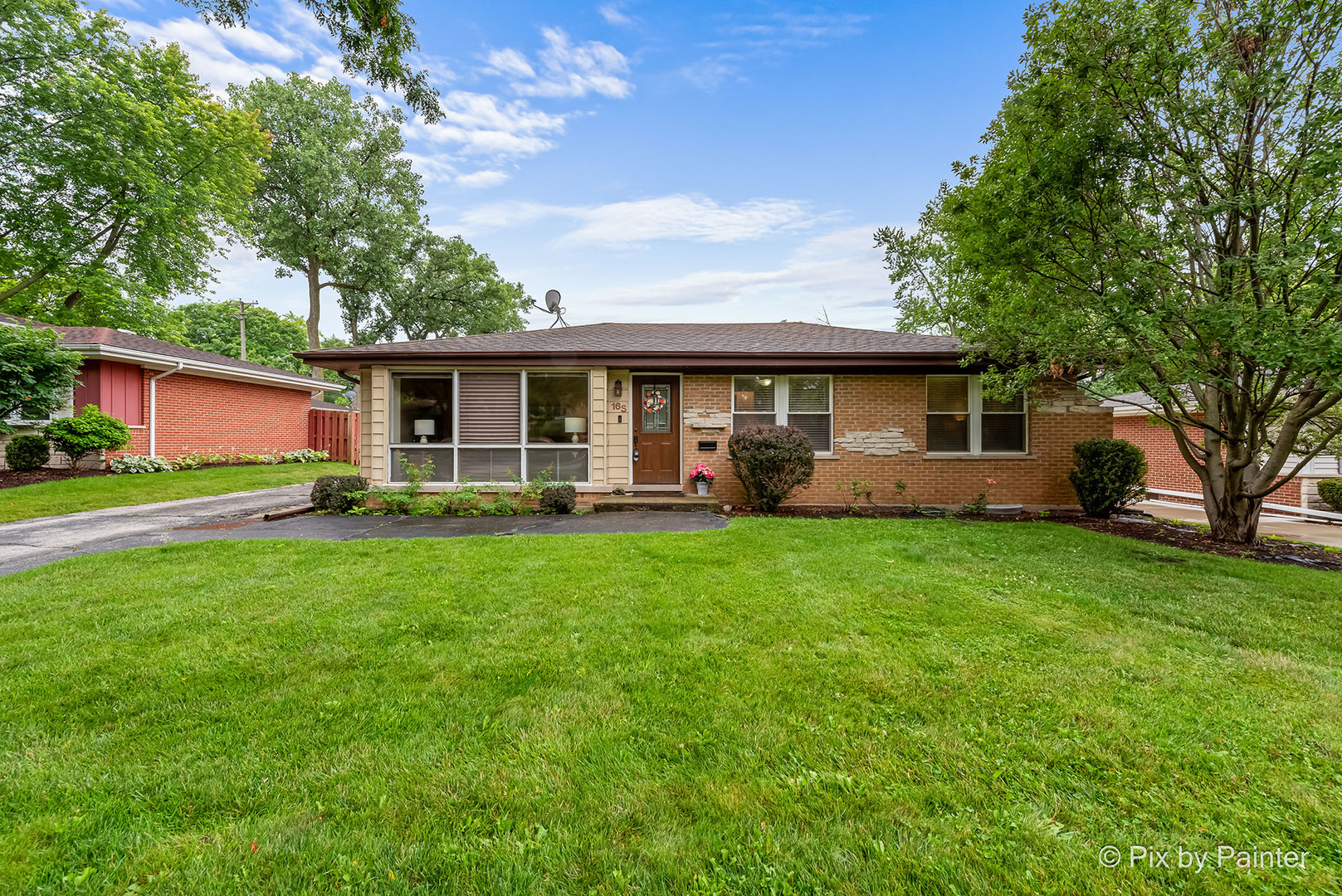 a front view of house with yard and green space