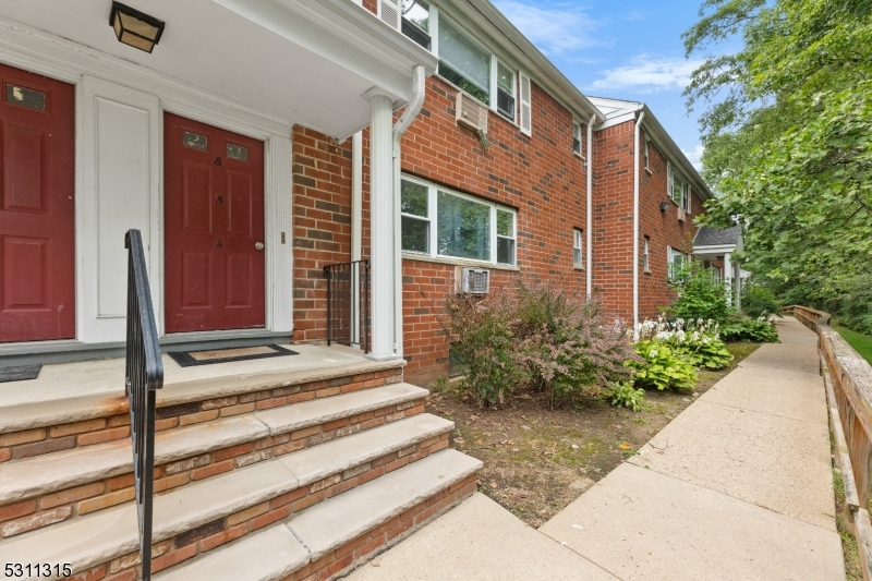 a view of a house with a door and a flower garden