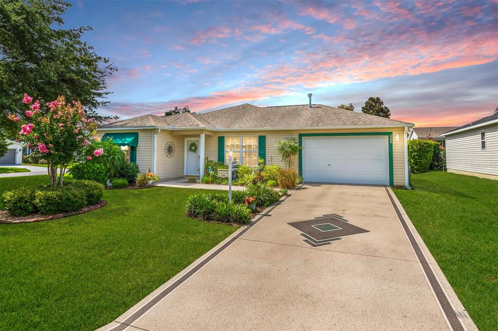 a front view of a house with a garden and yard