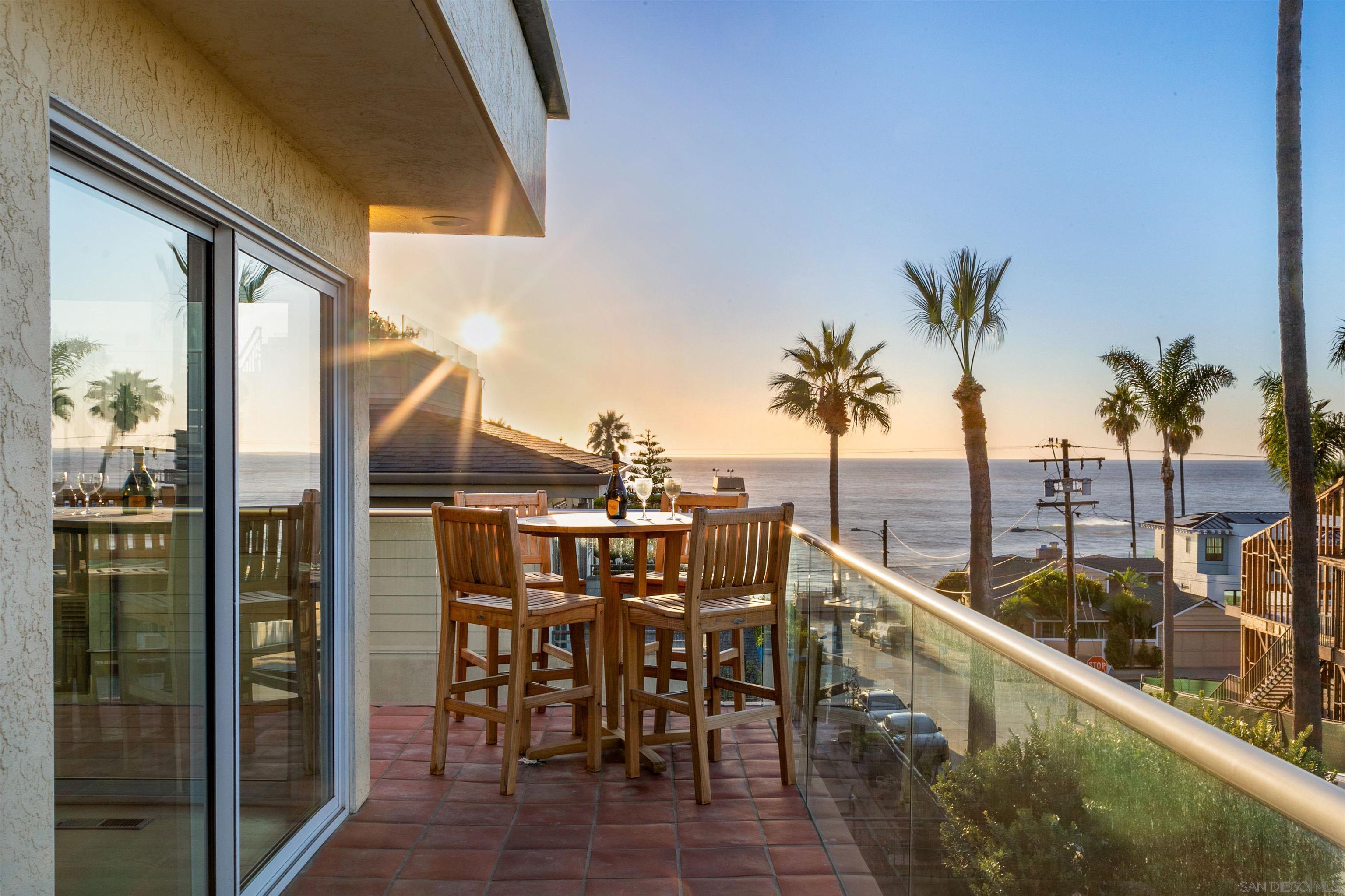 a view of a balcony with dining table chairs and wooden floor