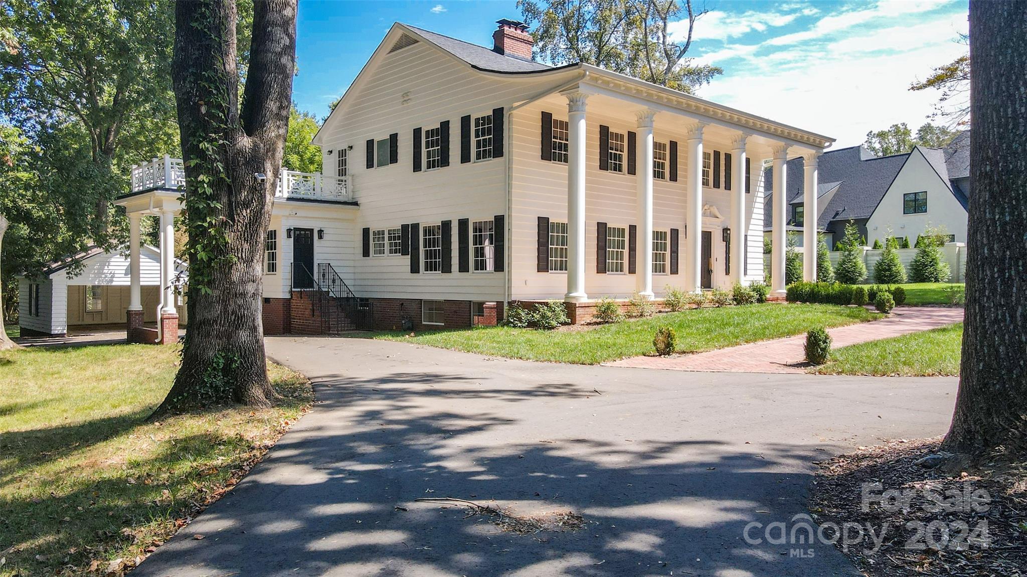 a front view of a house with a yard and trees