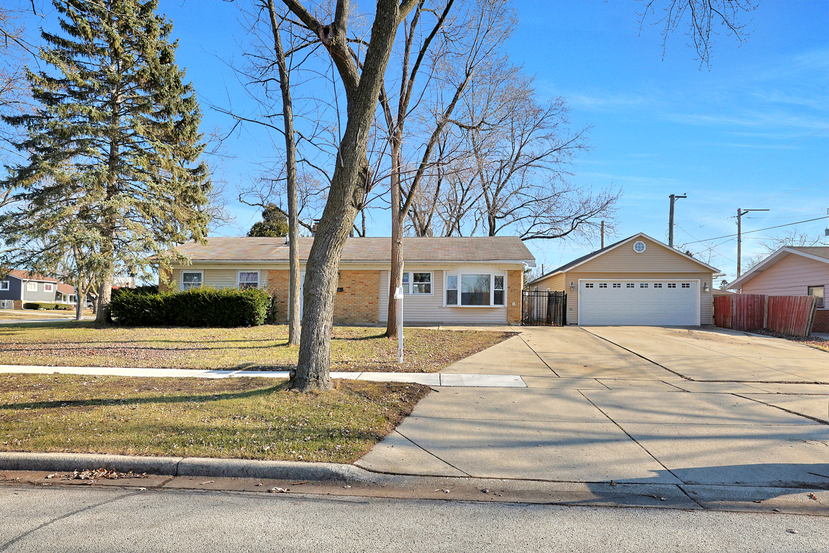 a front view of a house with a yard and large trees