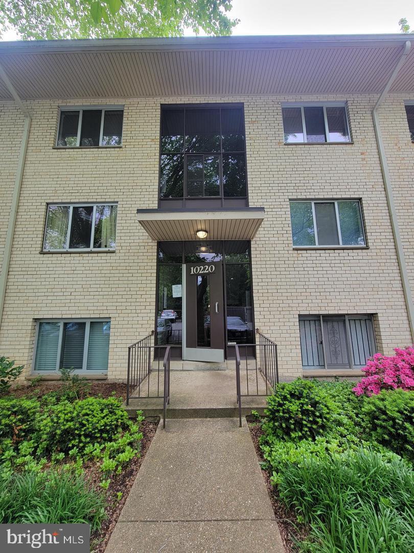 a front view of a building with a garden