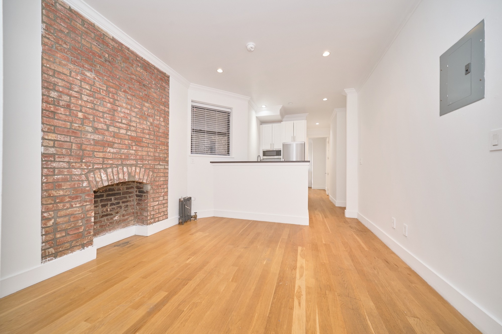 a view of a kitchen with wooden floor and a fireplace