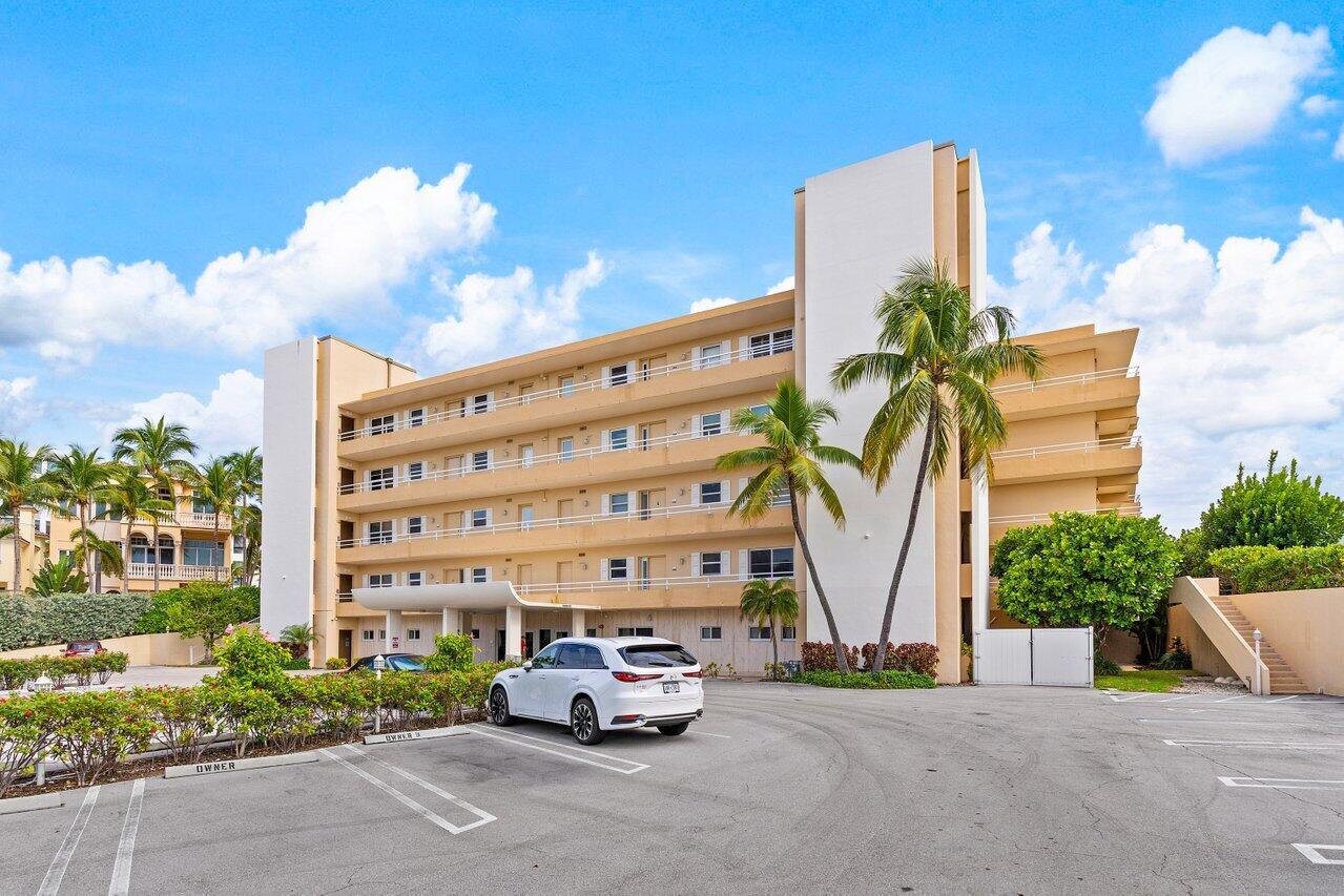 a car parked in front of a building with large trees