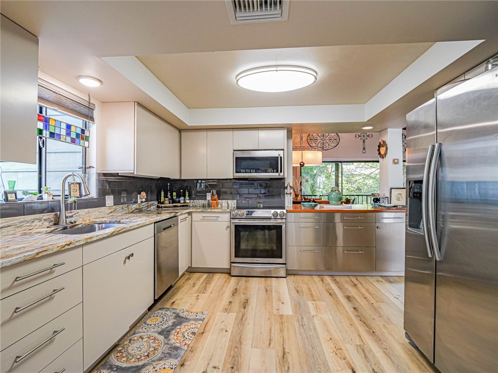 a kitchen with stainless steel appliances granite countertop a stove a sink and a refrigerator