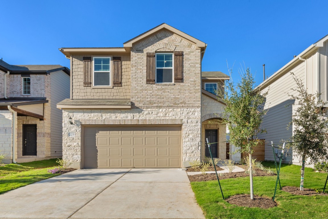 a front view of a house with a yard and garage