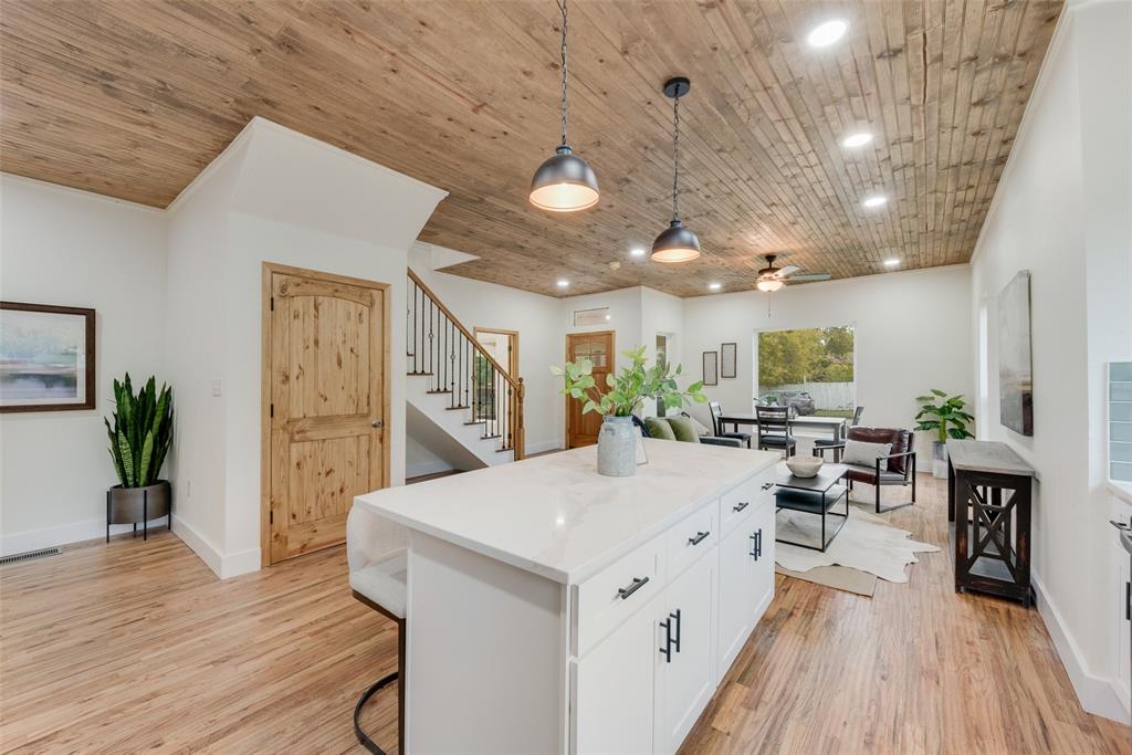 a large white kitchen with lots of counter space and wooden floor