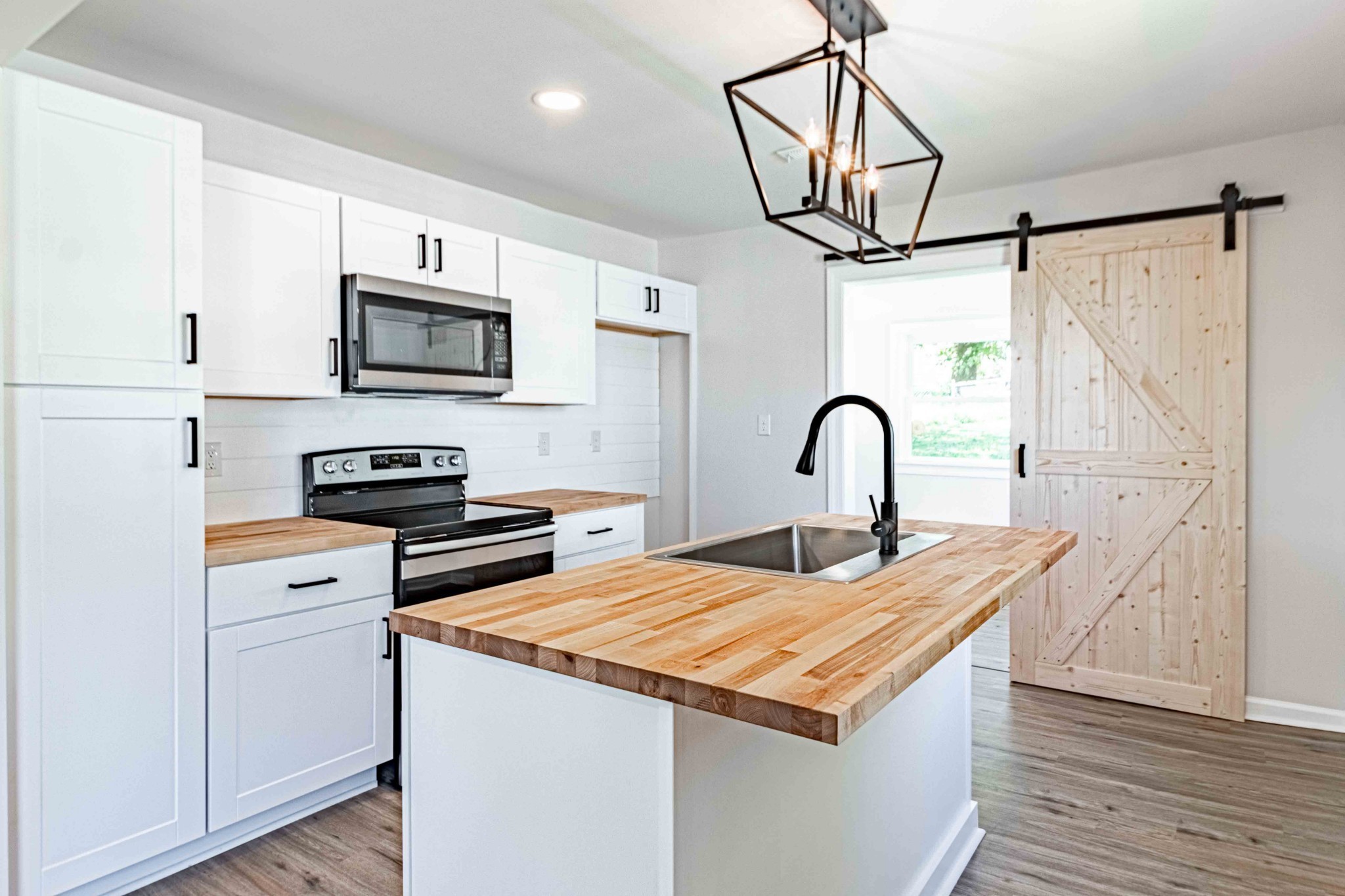 a kitchen with stainless steel appliances granite countertop a stove top oven a sink with wooden floors