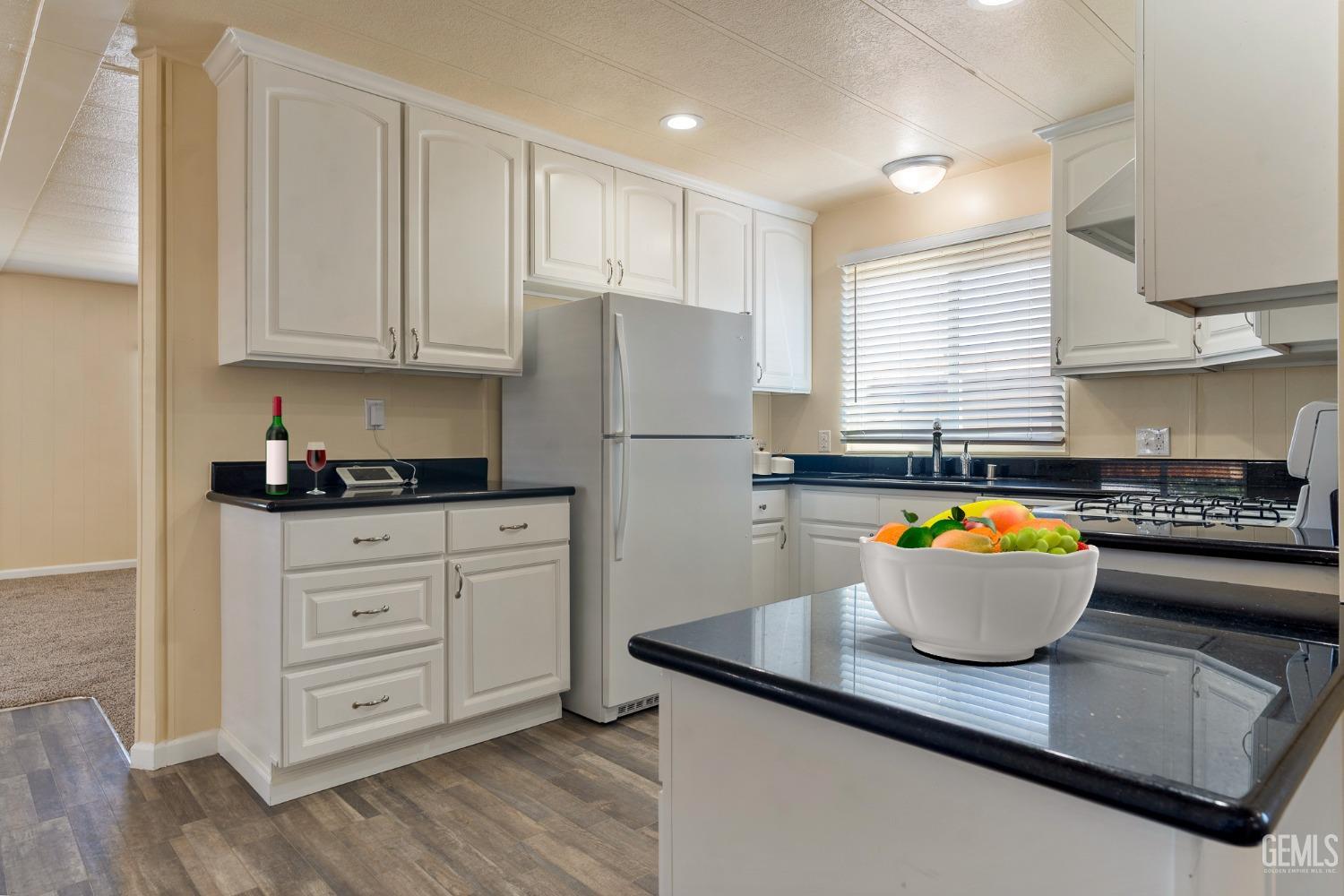 a kitchen with white cabinets and a refrigerator