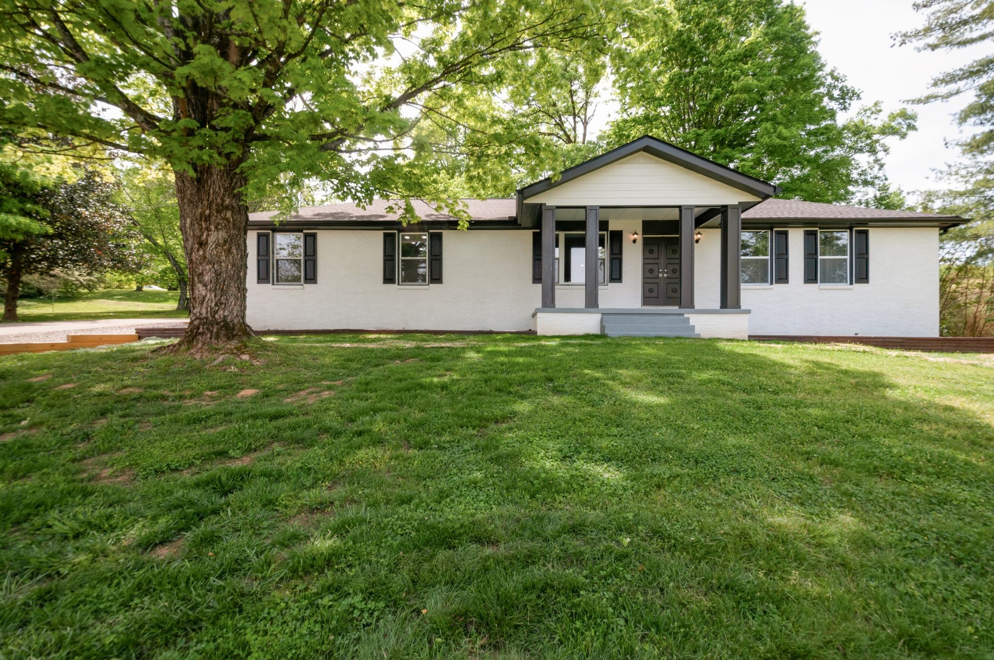 a front view of a house with a yard and trees