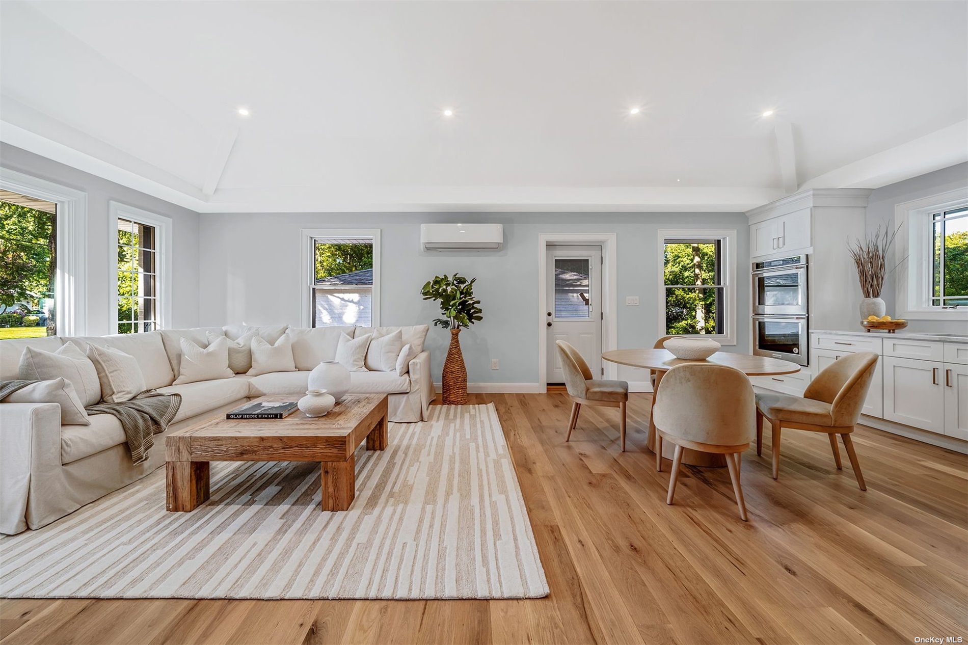 a living room with furniture a wooden floor and next to a window