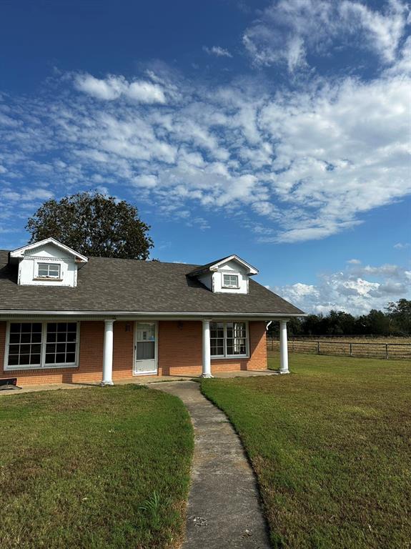 front view of a brick house with a yard