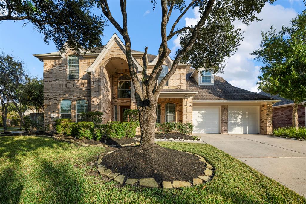 A beautiful corner lot home in Village Creek with a striking brick and stone elevation, lush landscaping, and a welcoming front porch. This home is just steps from the community clubhouse, pool, and parks.