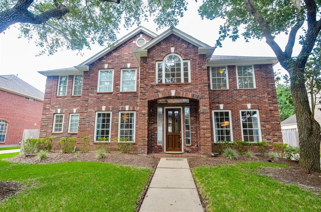 front view of a brick house with a yard