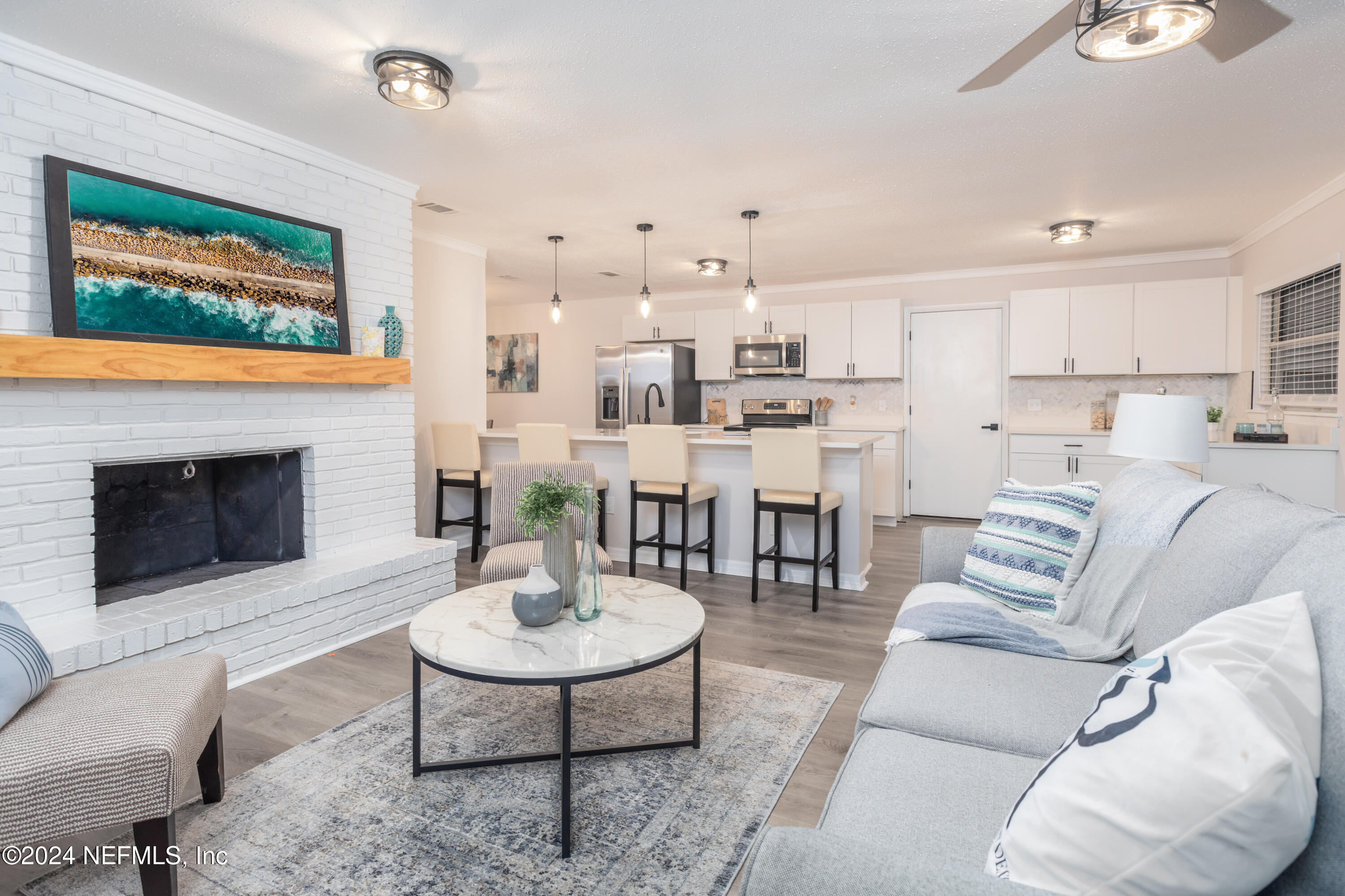 a living room with furniture a table and kitchen view