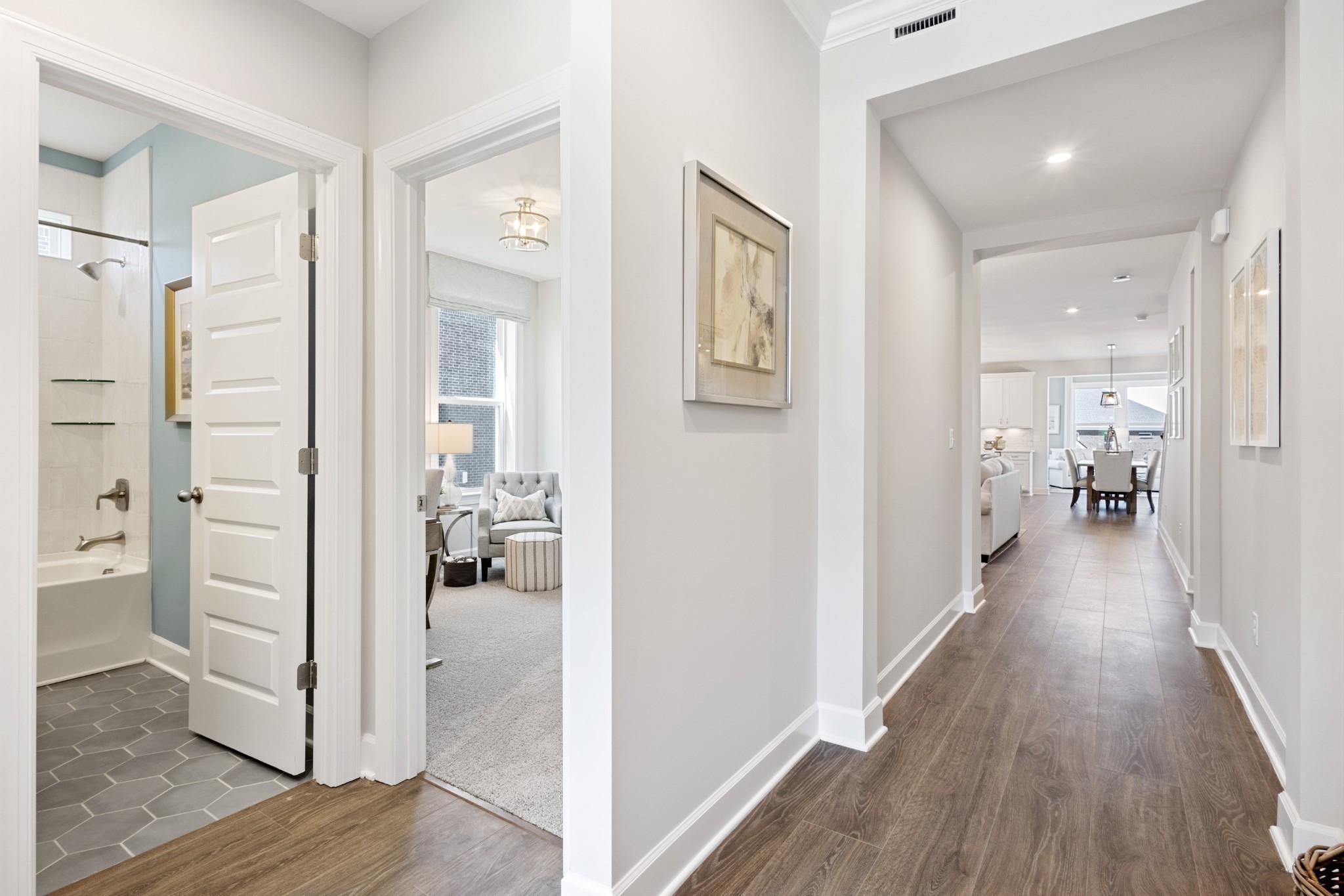 a view of a hallway with bathroom and wooden floor