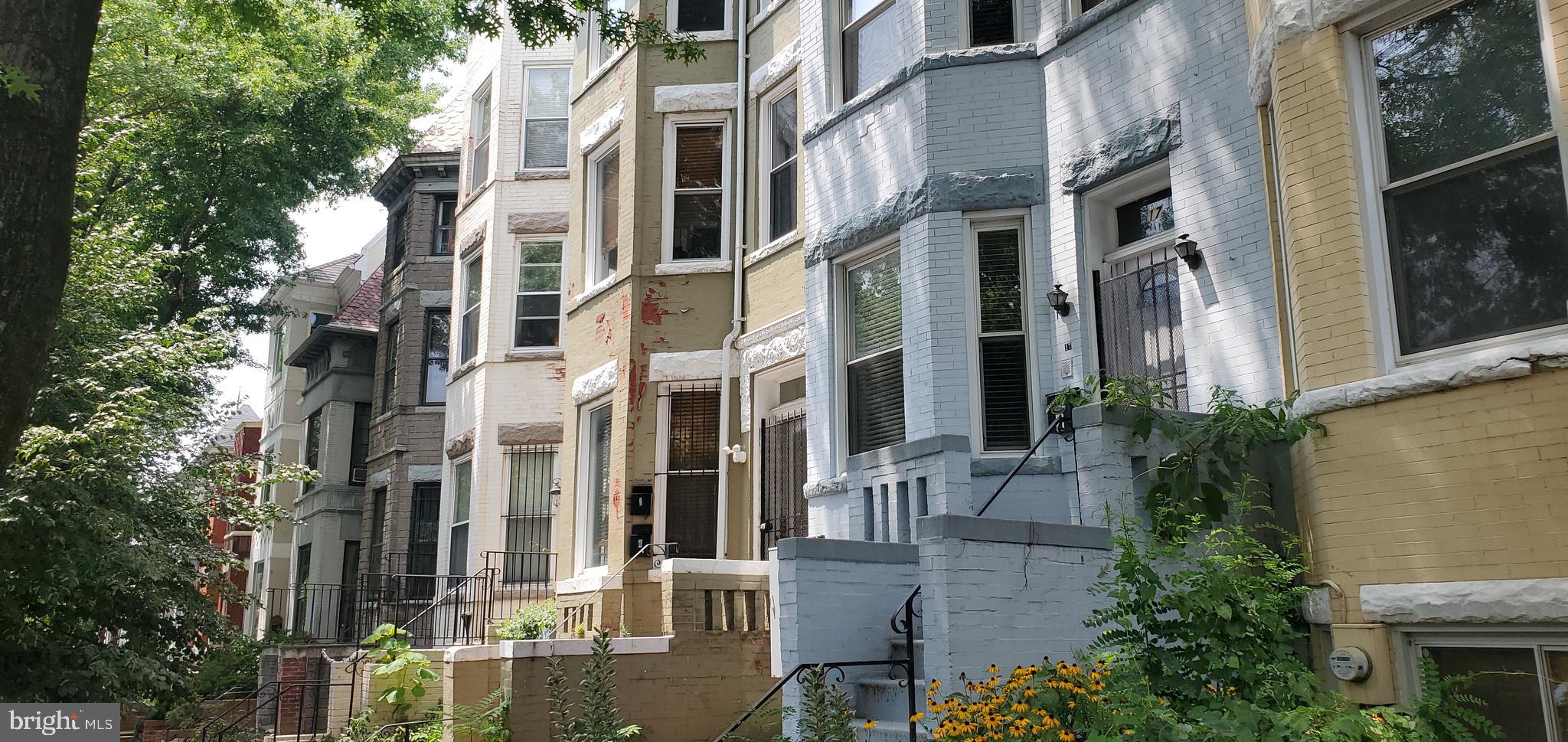 a front view of a multi story building with yard