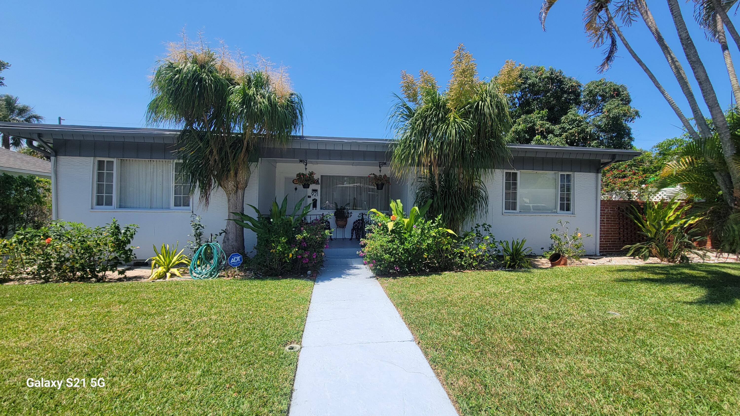 a front view of yellow house with a yard