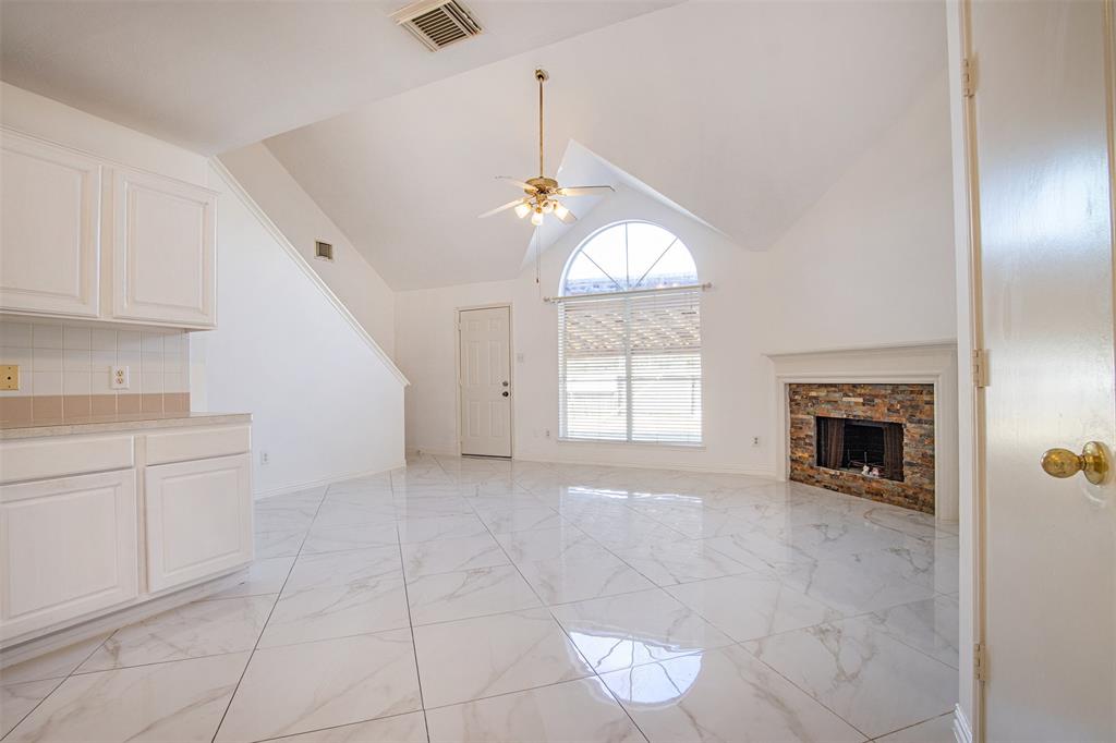 a view of an empty room with a fireplace and a window