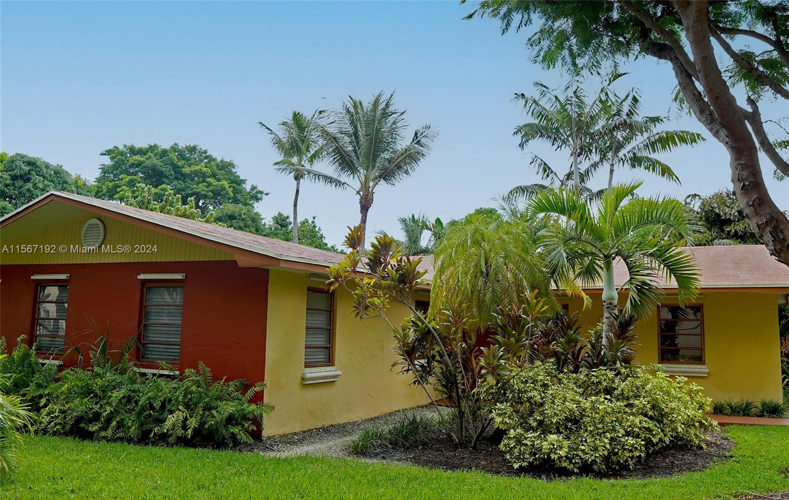 a front view of yellow house with a yard