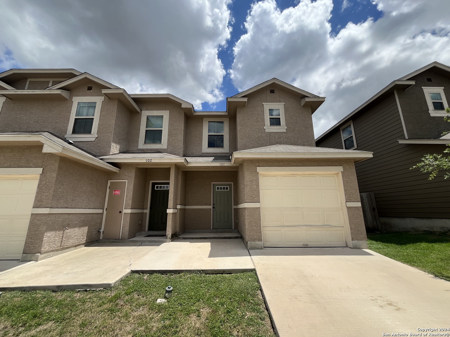 a front view of a house with a yard and garage