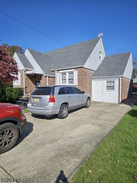 a front view of a house with cars parked