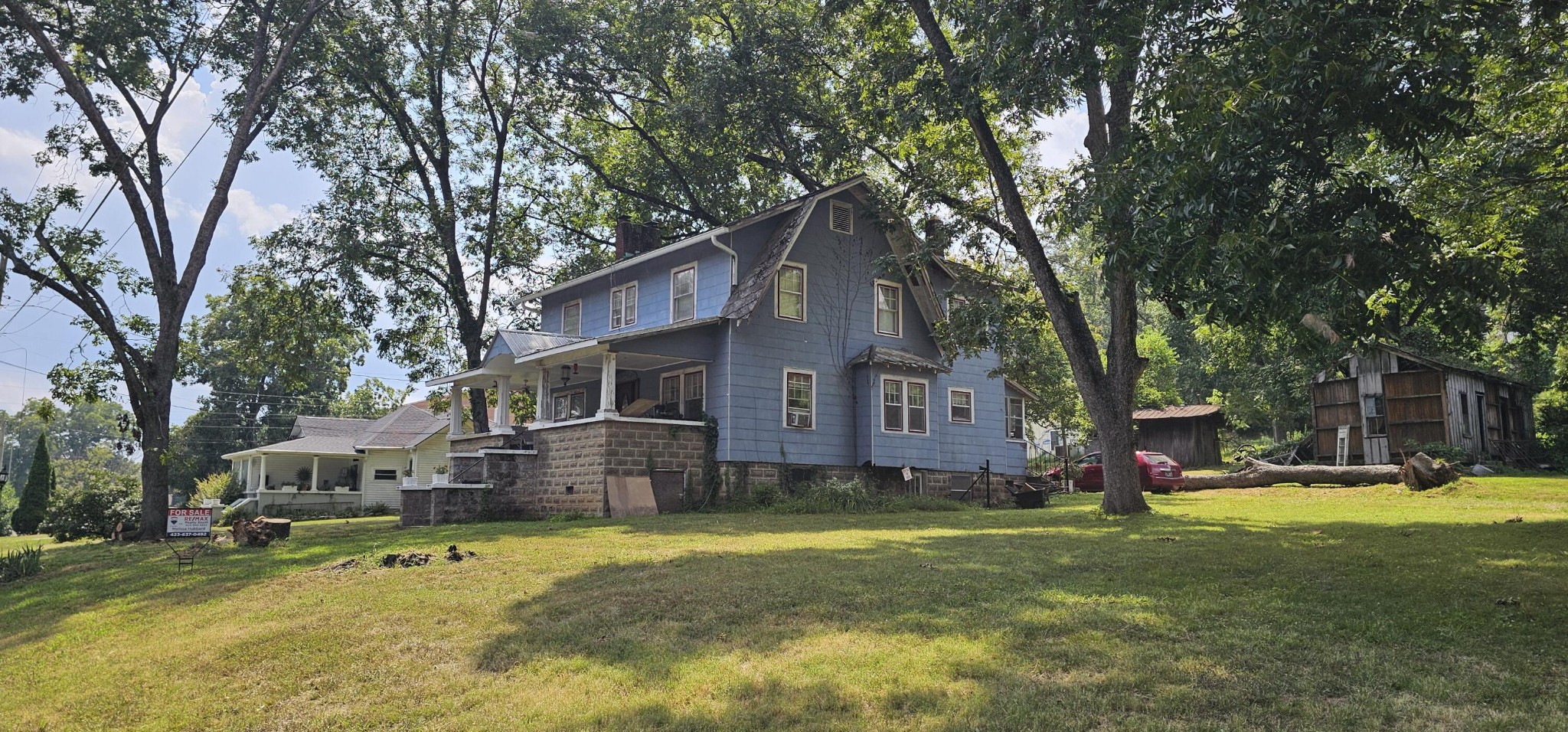 a view of a house with a big yard and large tree