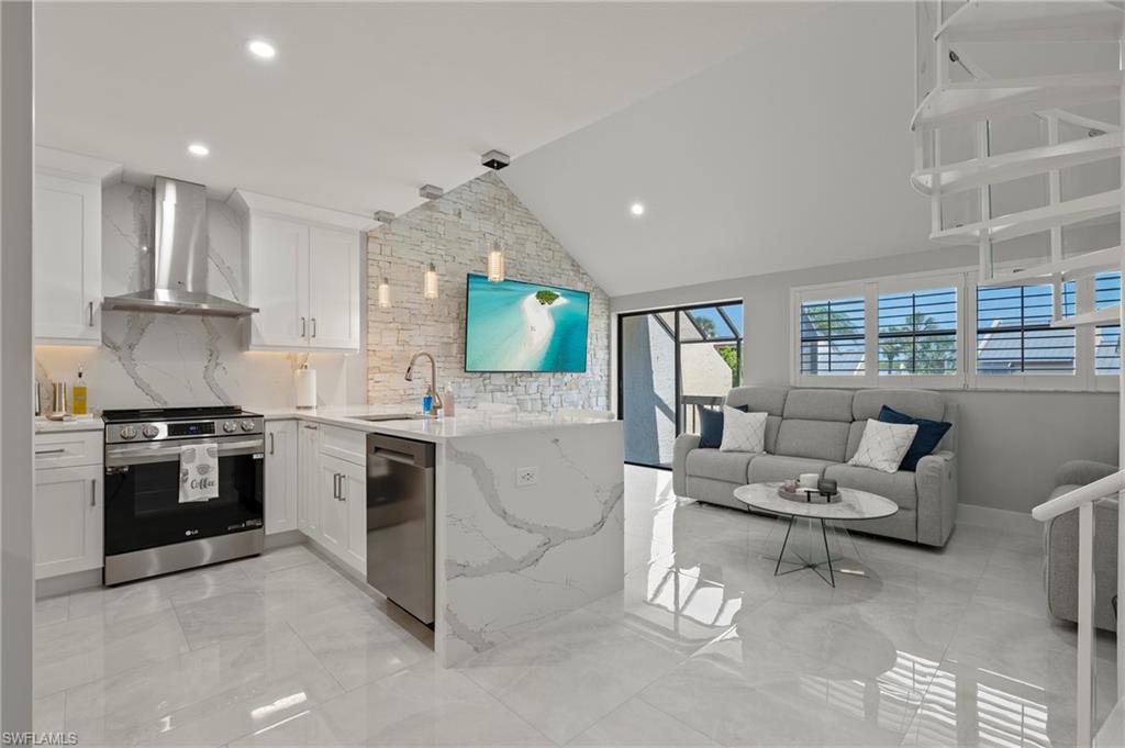 a kitchen with stainless steel appliances kitchen island granite countertop a stove and a view of living room