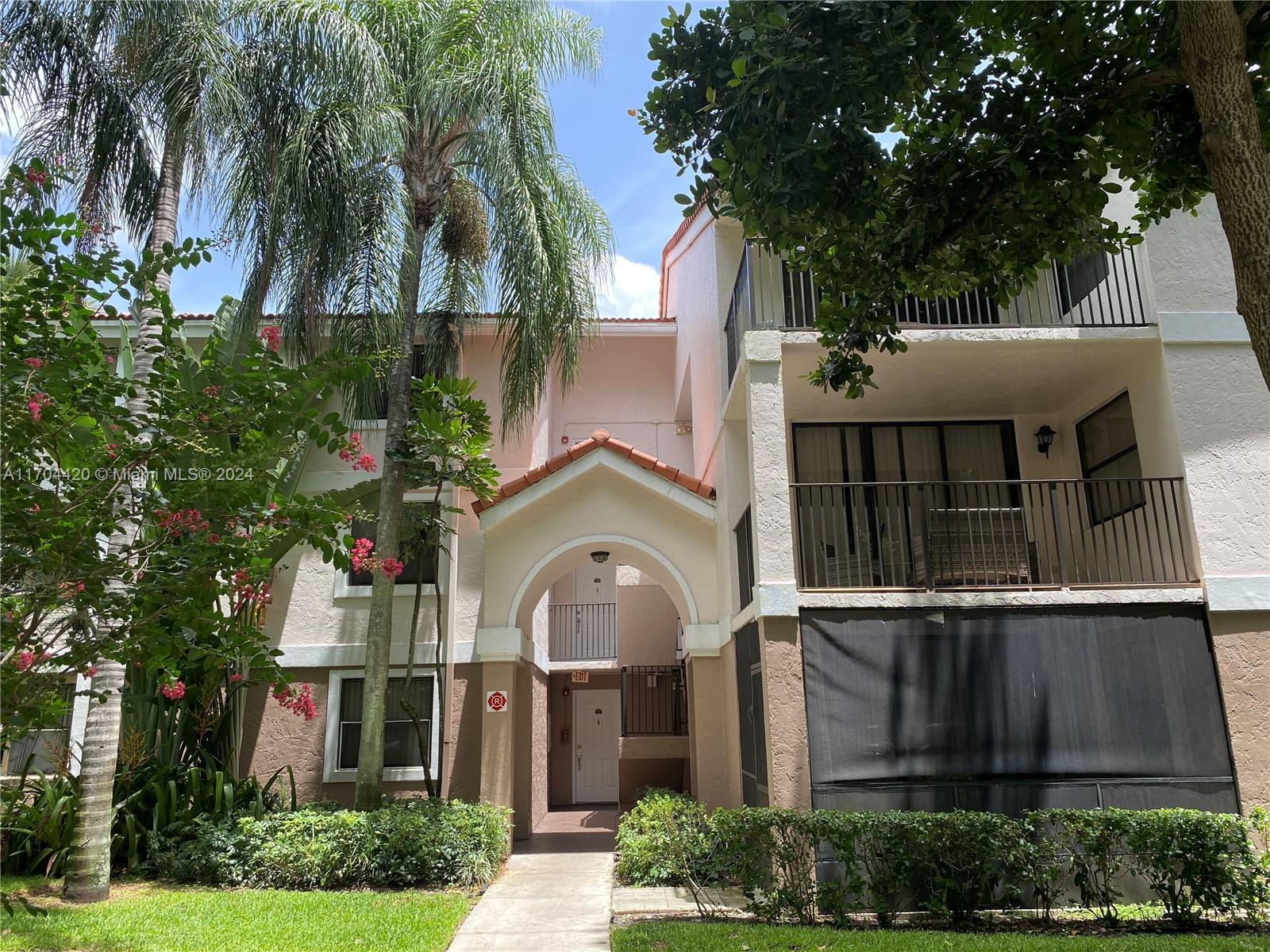 a front view of a house with a yard and potted plants