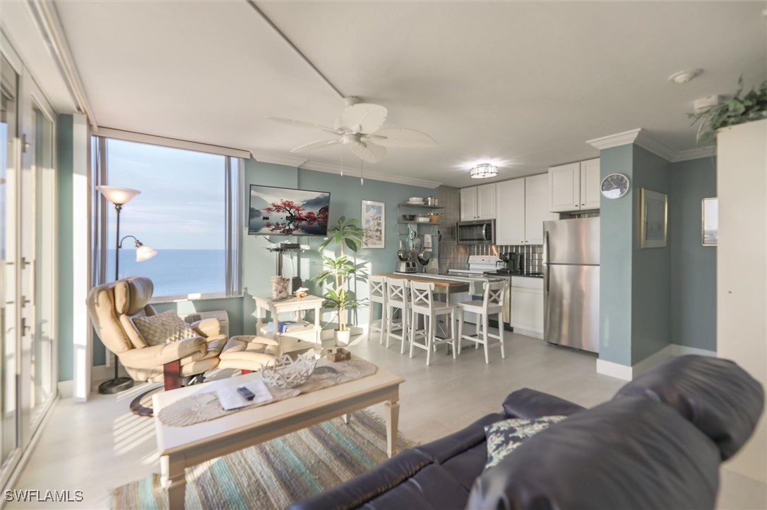 a living room with furniture and a dining table with kitchen view