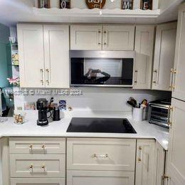 a kitchen with white cabinets a sink and wooden floor