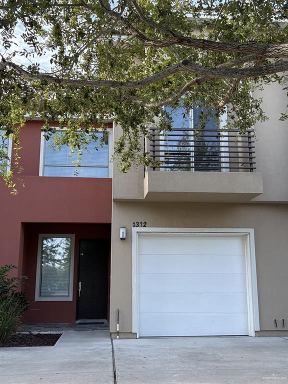 View of front of house with a garage and a balcony