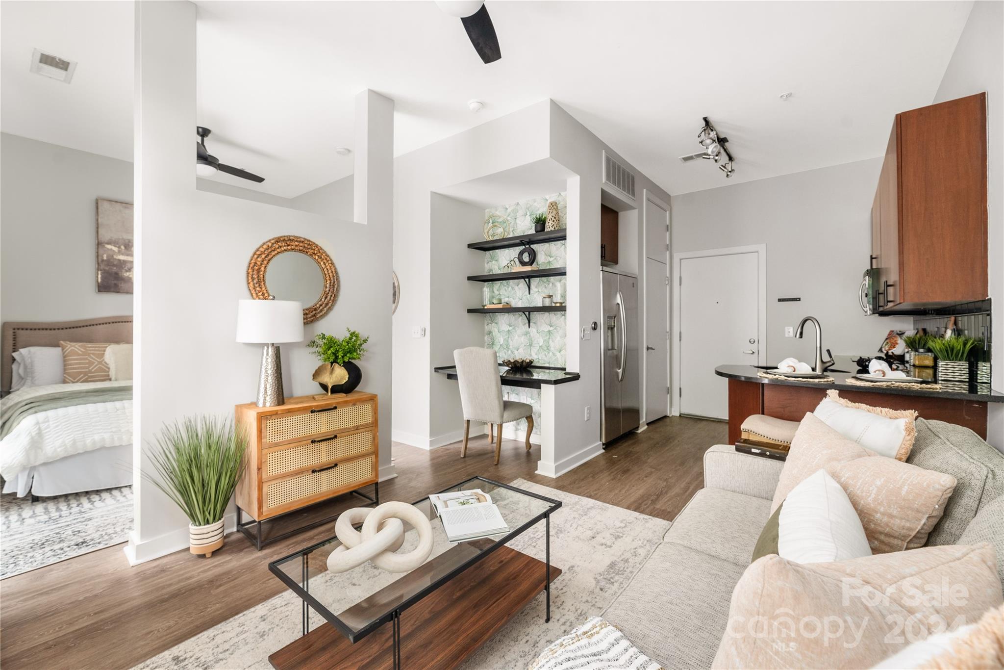 a living room with furniture cabinets and wooden floor