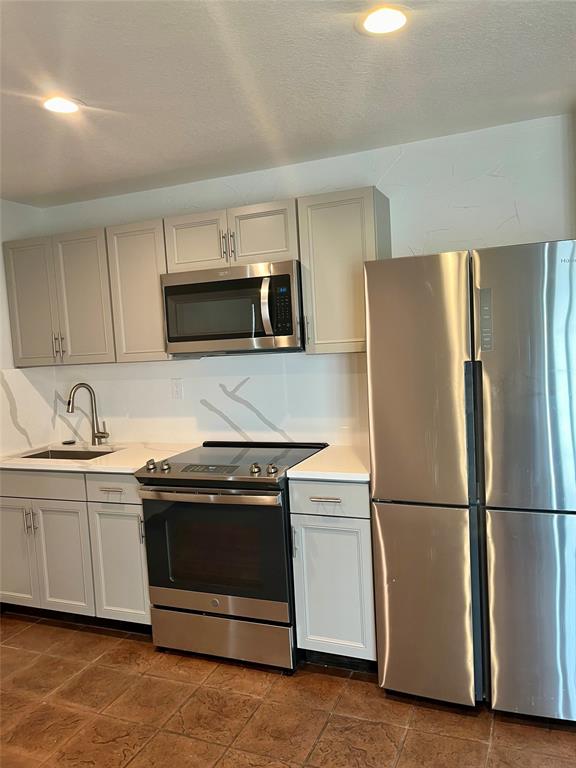 a kitchen with a sink and steel appliances