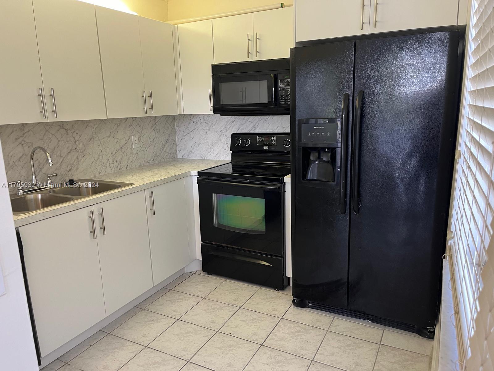 a kitchen with a refrigerator and a sink