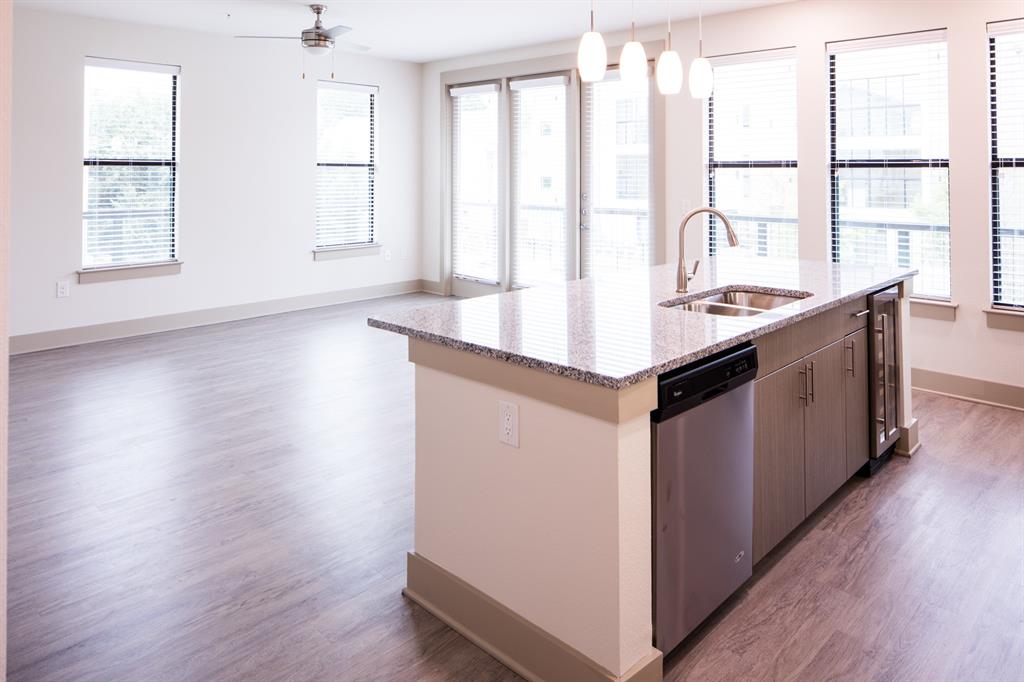 a kitchen with kitchen island wooden floor and a large window