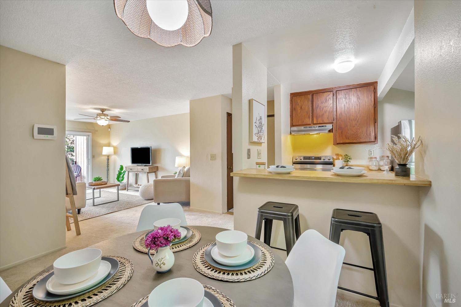 a kitchen with stainless steel appliances granite countertop a dining table and chairs