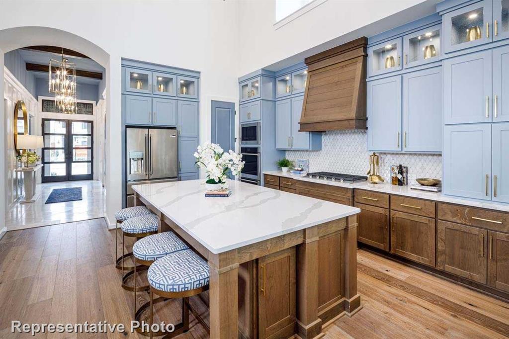 a kitchen with stainless steel appliances kitchen island granite countertop a table chairs in it and wooden floors