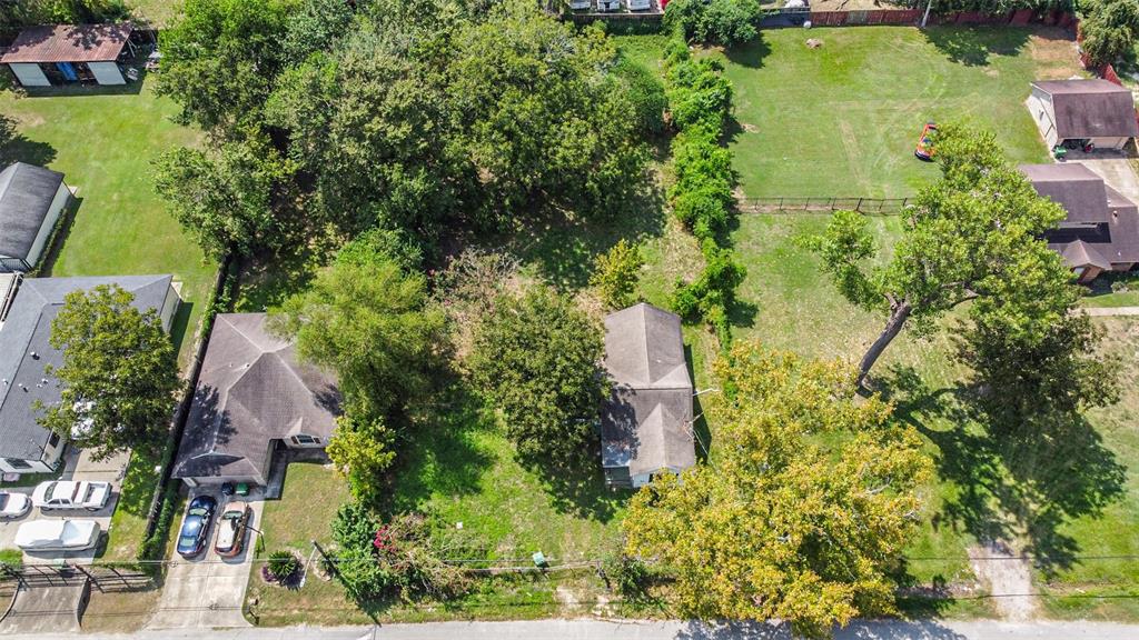 an aerial view of residential house with outdoor space and trees all around