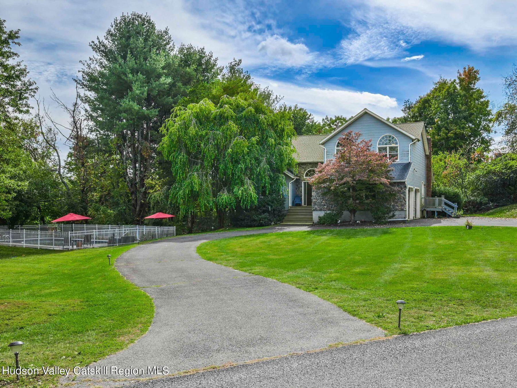 a view of a house with a backyard and a tree